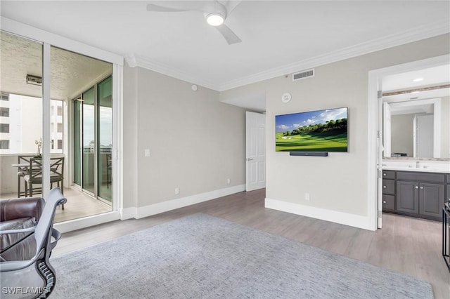 unfurnished living room with light wood-type flooring, ceiling fan, and ornamental molding