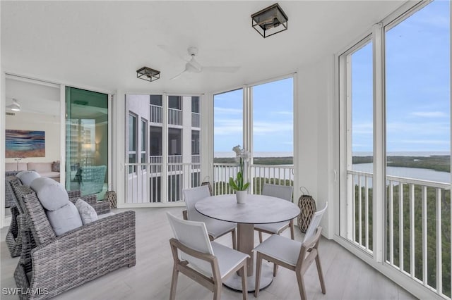 sunroom / solarium featuring a water view and plenty of natural light