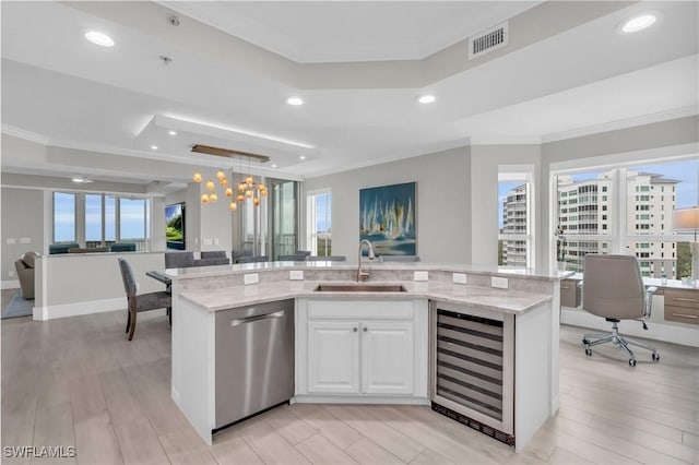 kitchen with a sink, a raised ceiling, dishwasher, wine cooler, and visible vents