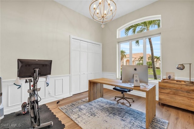 office featuring wood-type flooring, plenty of natural light, and a chandelier