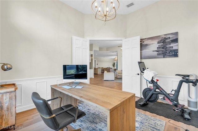 office space featuring light hardwood / wood-style floors and a notable chandelier