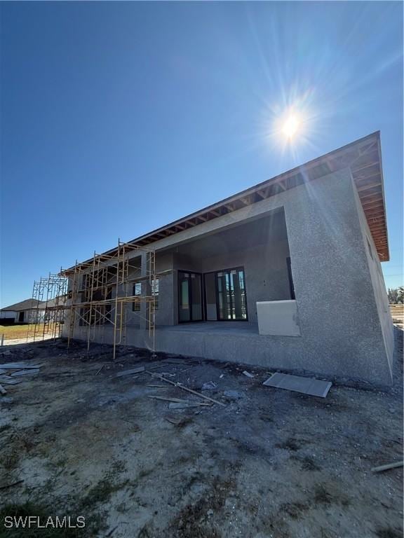 back of property with stucco siding and a patio