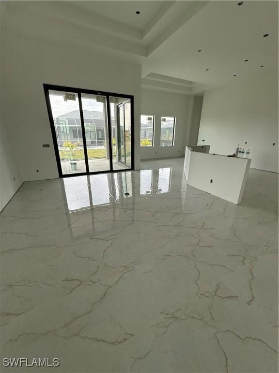 unfurnished room with marble finish floor and a high ceiling