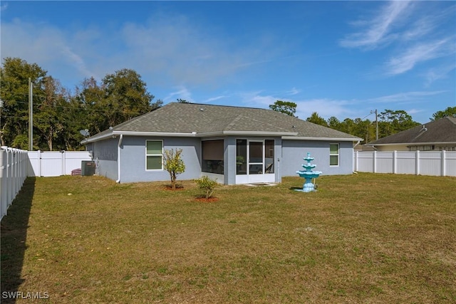 rear view of house with cooling unit and a lawn