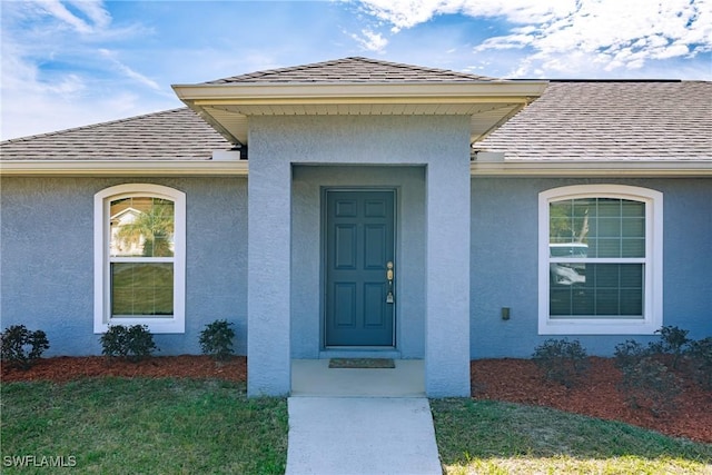 property entrance with a lawn