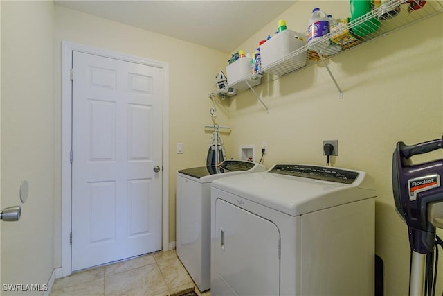 laundry area featuring washer and dryer and light tile patterned floors