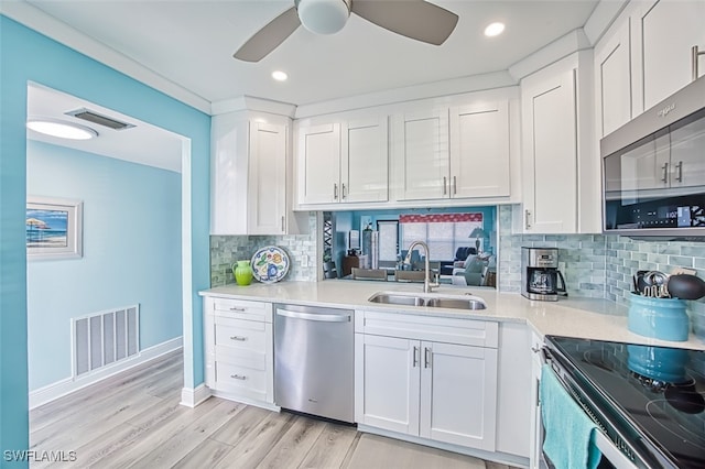 kitchen featuring stainless steel appliances, white cabinets, visible vents, and a sink