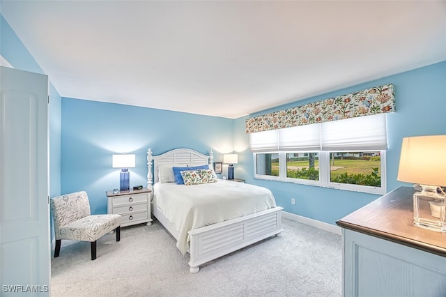 bedroom featuring baseboards and light colored carpet