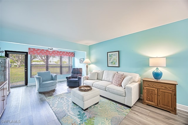 living area with light wood-type flooring and baseboards