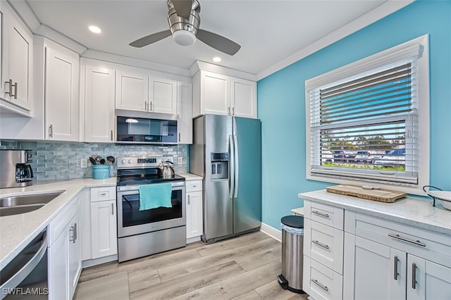 kitchen with white cabinets, stainless steel appliances, and backsplash