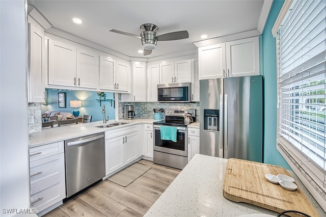 kitchen featuring light countertops, appliances with stainless steel finishes, a sink, and white cabinetry