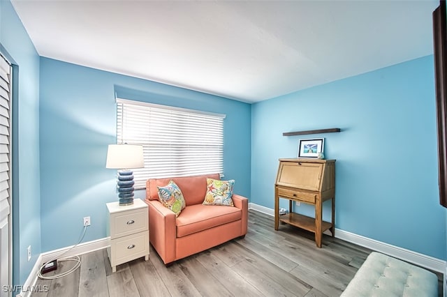 living area with light wood-style flooring and baseboards