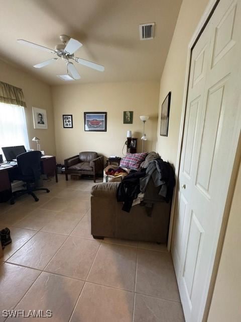 tiled living room featuring ceiling fan