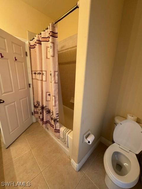 bathroom with tile patterned floors, toilet, and shower / tub combo