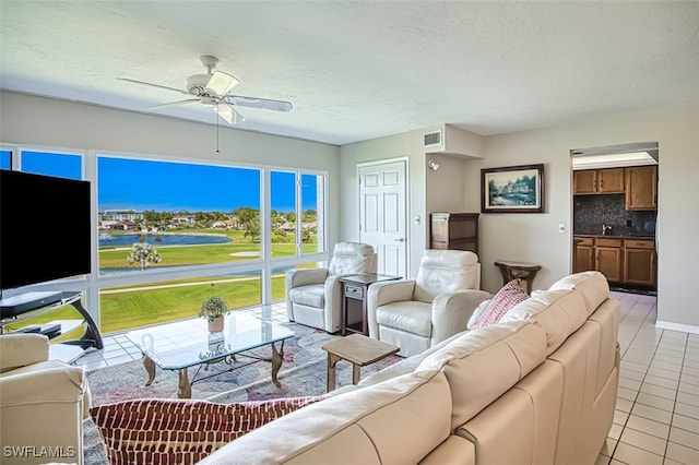 tiled living room featuring ceiling fan and a textured ceiling