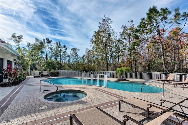 view of swimming pool featuring an in ground hot tub and a patio