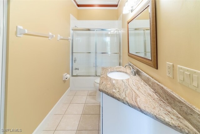 full bathroom with toilet, enclosed tub / shower combo, tile patterned flooring, ornamental molding, and vanity