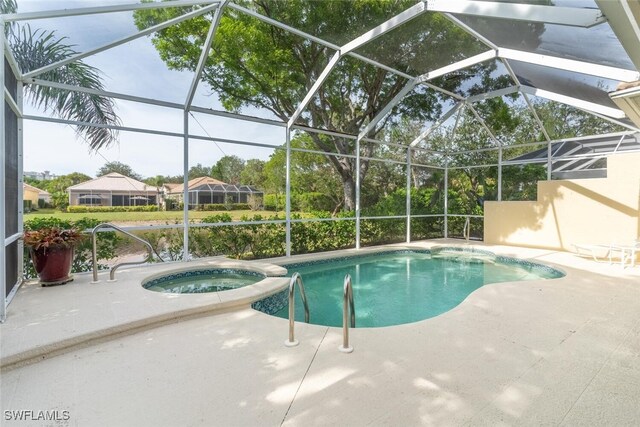 view of pool with a patio area, glass enclosure, and an in ground hot tub