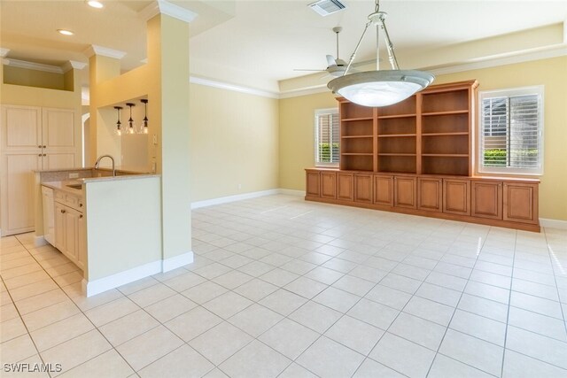 interior space with decorative light fixtures, sink, kitchen peninsula, light tile patterned floors, and crown molding