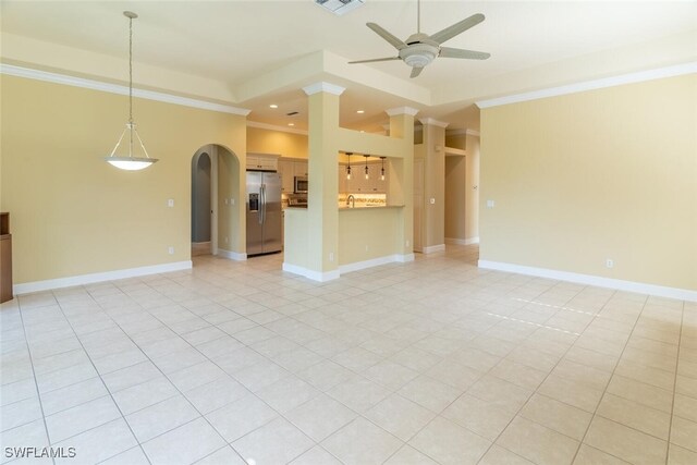 unfurnished living room featuring ceiling fan, light tile patterned floors, a tray ceiling, and ornamental molding