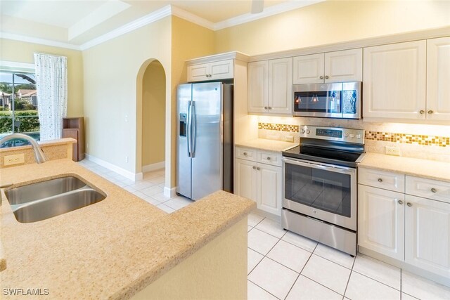 kitchen with light tile patterned floors, appliances with stainless steel finishes, tasteful backsplash, and sink