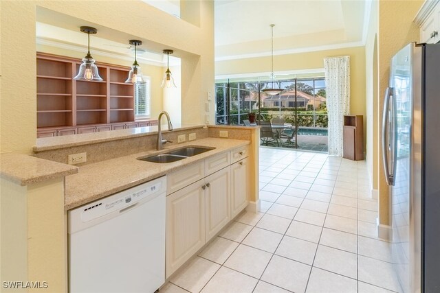 kitchen featuring light tile patterned floors, a raised ceiling, dishwasher, stainless steel refrigerator, and sink