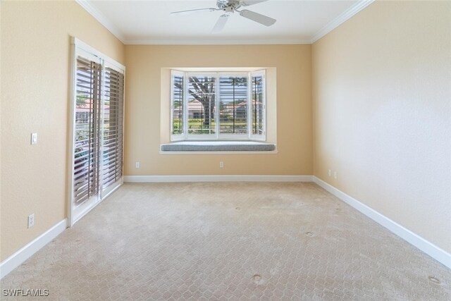 carpeted empty room featuring ceiling fan and crown molding