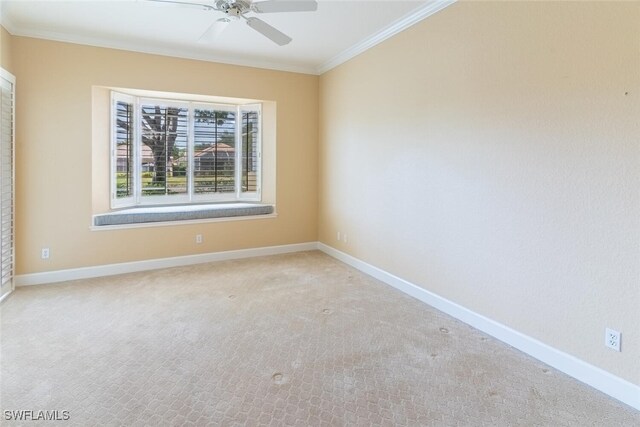 spare room featuring ceiling fan, ornamental molding, and light colored carpet