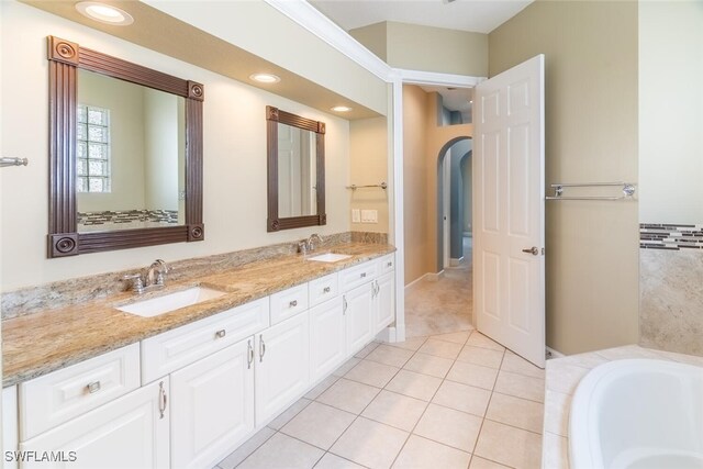 bathroom featuring tiled bath, vanity, and tile patterned floors