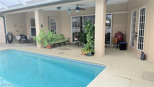 view of pool featuring a lanai, a patio area, french doors, and ceiling fan