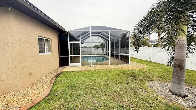 view of yard featuring a fenced in pool and glass enclosure