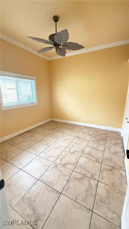 spare room with ornamental molding, light tile patterned floors, and ceiling fan