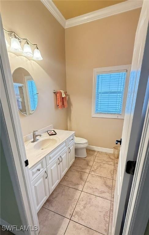 bathroom featuring tile patterned flooring, crown molding, vanity, and toilet