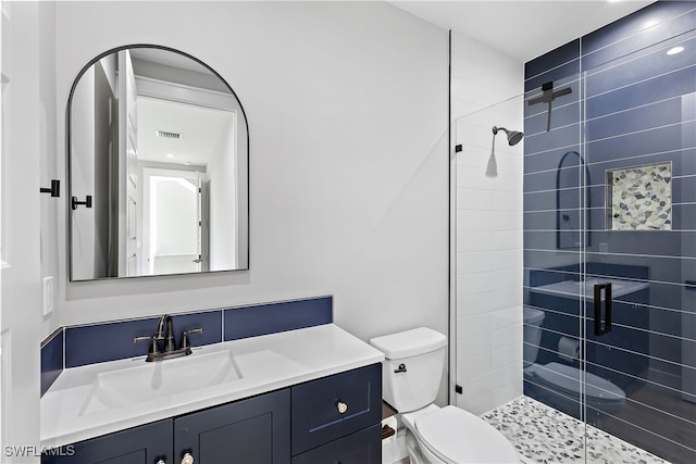 bathroom featuring vanity, a shower with shower door, and toilet