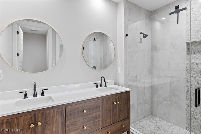 bathroom featuring a shower with shower door and vanity