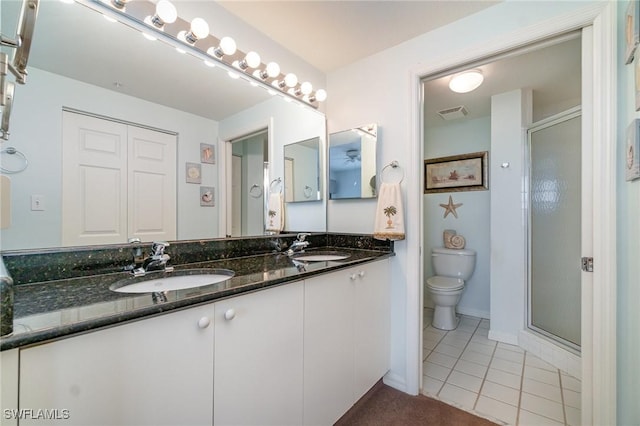 bathroom featuring tile patterned floors, vanity, toilet, and an enclosed shower