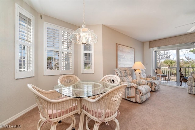 carpeted dining room with ceiling fan