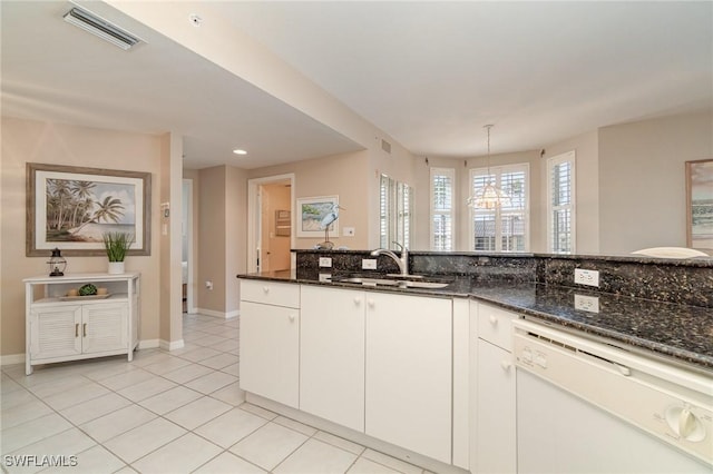 kitchen with pendant lighting, sink, dishwasher, white cabinetry, and dark stone countertops