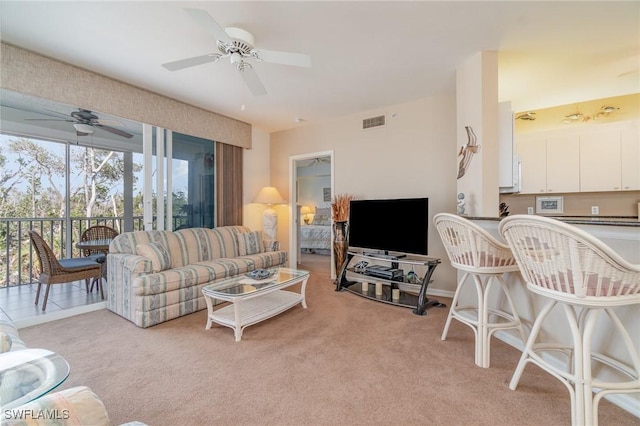 carpeted living room with ceiling fan