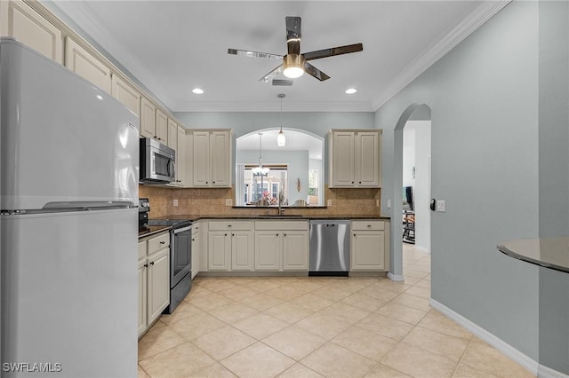 kitchen with sink, ornamental molding, stainless steel appliances, cream cabinets, and decorative backsplash