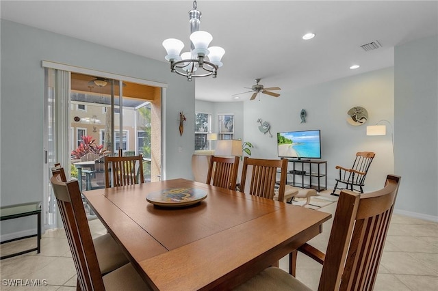 tiled dining area with ceiling fan with notable chandelier