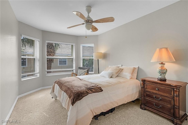 bedroom featuring multiple windows, light colored carpet, and ceiling fan