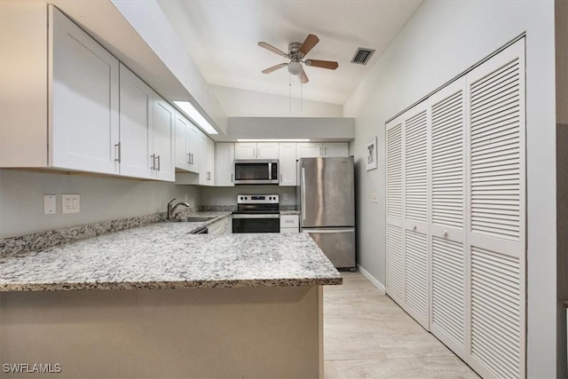 kitchen with visible vents, appliances with stainless steel finishes, white cabinetry, a sink, and light stone countertops