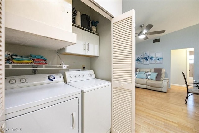 laundry area featuring a ceiling fan, visible vents, washer and dryer, light wood-type flooring, and cabinet space