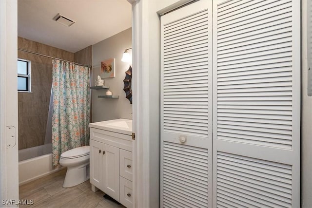 bathroom featuring toilet, vanity, visible vents, a closet, and shower / bath combo