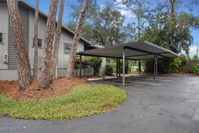 partially covered parking lot featuring fence