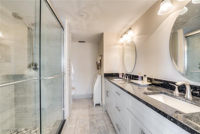 bathroom featuring vanity, an enclosed shower, and toilet