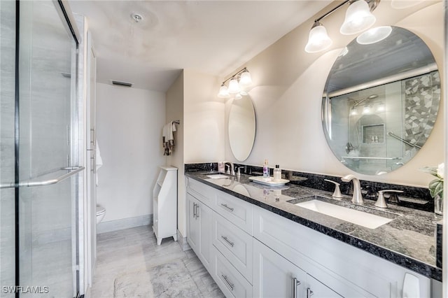 bathroom featuring an enclosed shower, vanity, and toilet