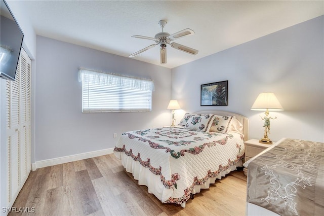 bedroom featuring hardwood / wood-style flooring, ceiling fan, and a closet