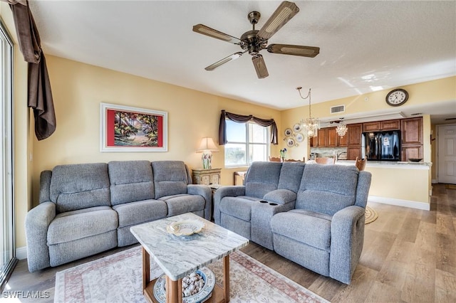 living room with ceiling fan and light hardwood / wood-style flooring